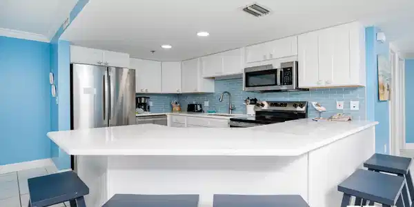 Image 2: Kitchen featuring white cabinets, stainless steel appliances, a kitchen breakfast bar, light tile patterned floors, and recessed lighting