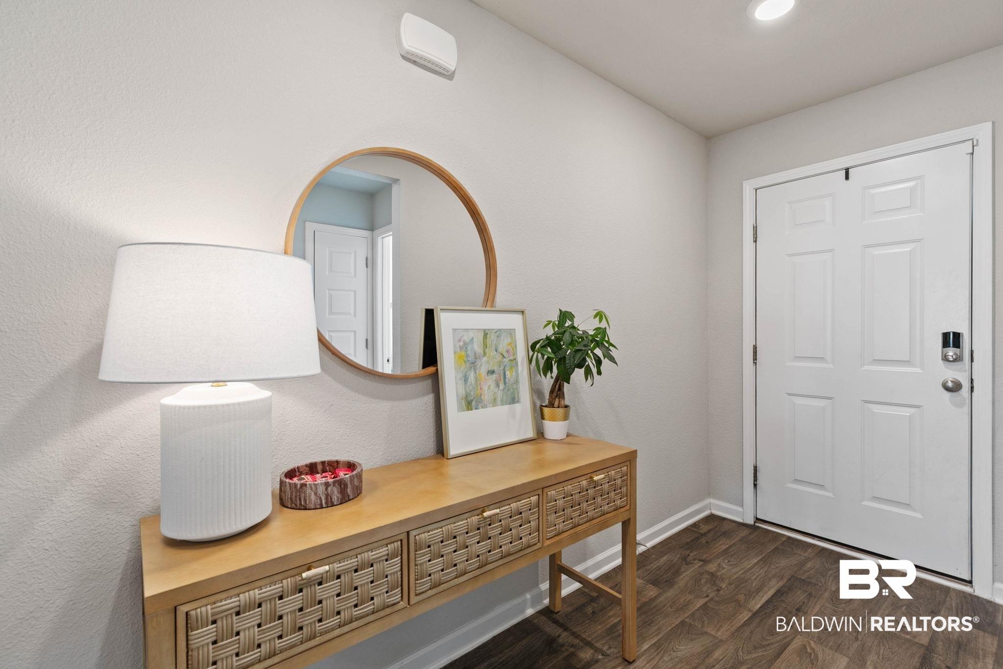 Image 4: Entryway featuring a paneled door, wood-finish flooring, and light-toned walls