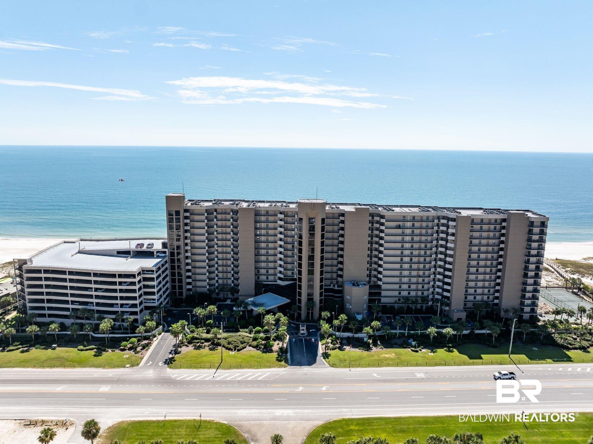 Image 1: Bird's eye view of apartment complex and expansive coastline