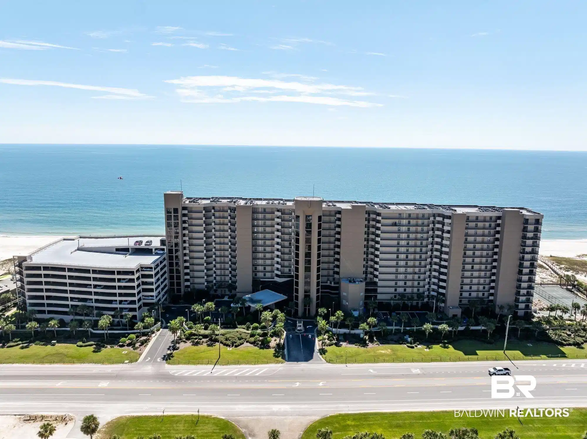 Image 1: Bird's eye view of apartment complex and expansive coastline