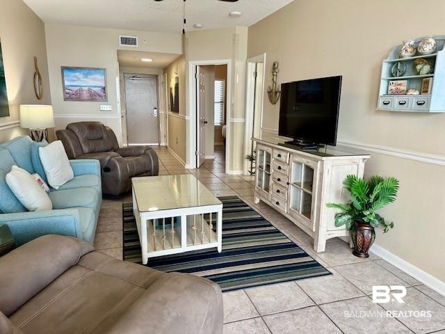 Image 3: Living area with light tile patterned flooring and a ceiling fan