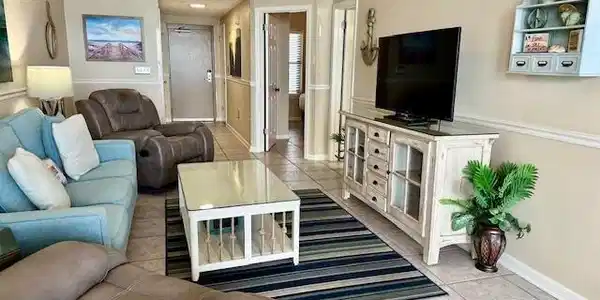 Image 3: Living area with light tile patterned flooring and a ceiling fan