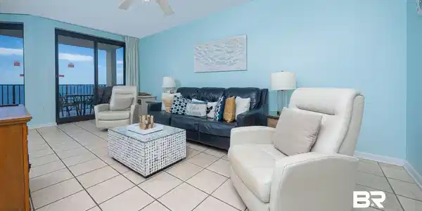Image 2: Living area with light tile patterned floors and ceiling fan