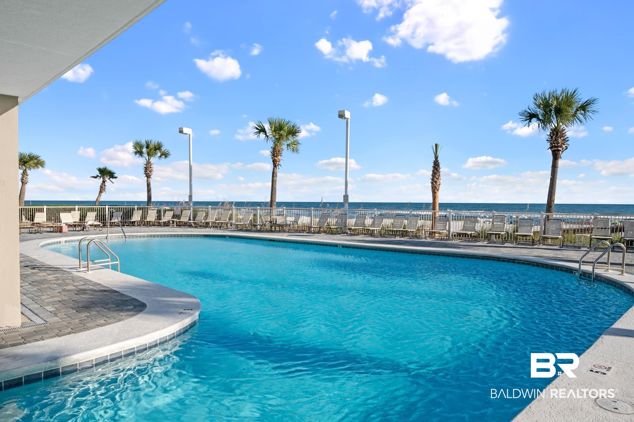 Image 2: Community pool featuring a patio area and a water view