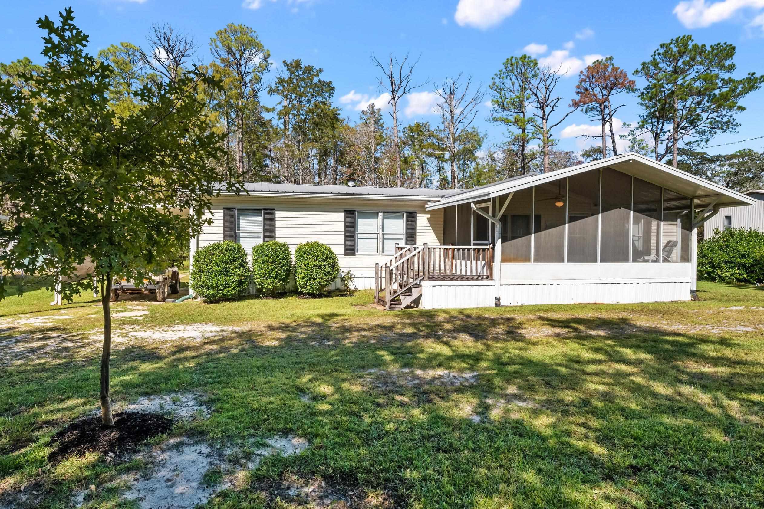 Image 3: View of front of property with a sunroom and a front yard