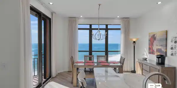 Image 4: Dining space with a water view, wood finished floors, a chandelier, recessed lighting, and a textured ceiling