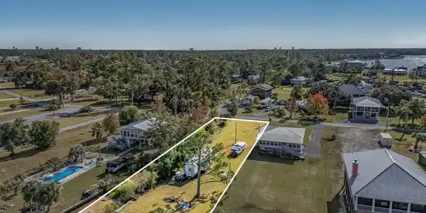 Image 2: Aerial overview of property's location featuring property parcel outlined and a large body of water