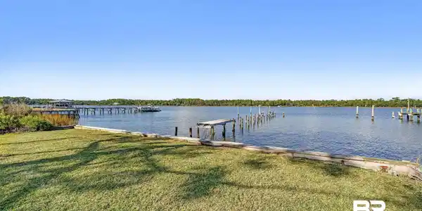 Image 3: Dock area featuring a yard and a water view