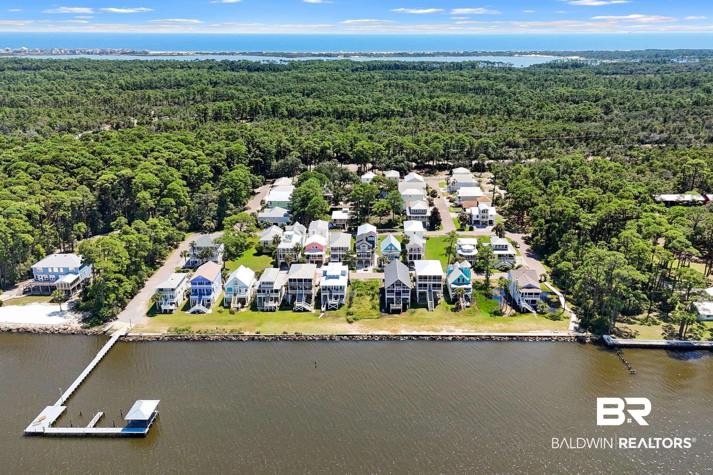 Image 3: Aerial perspective of suburban area featuring a large body of water and a heavily wooded area