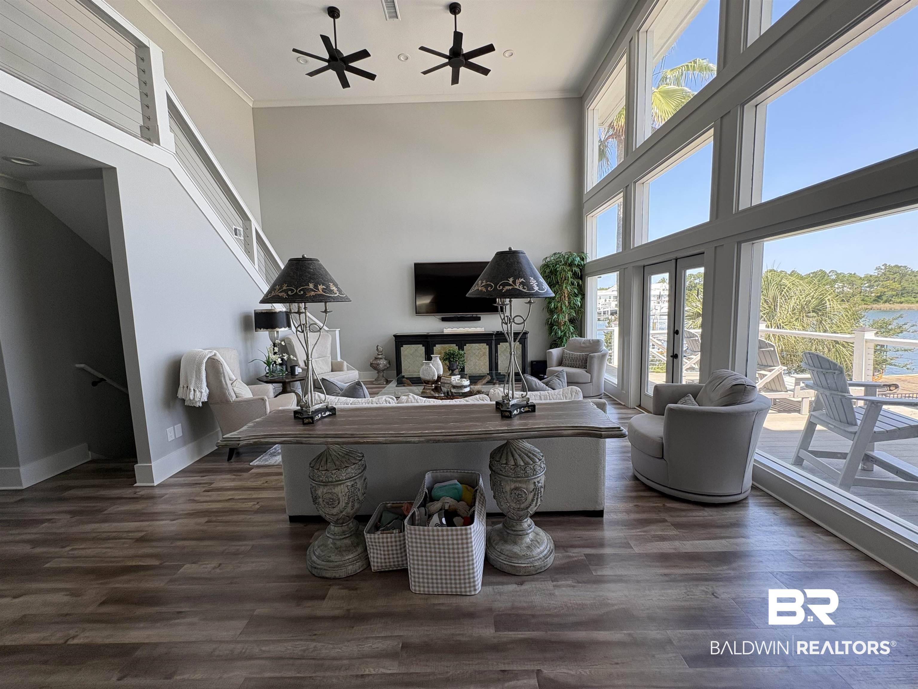 Image 4: Two-story living area featuring a vaulted ceiling and wood-finish flooring