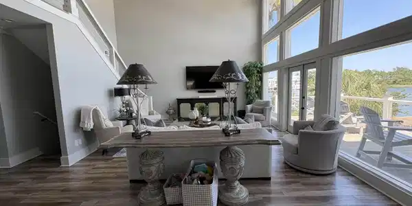 Image 4: Two-story living area featuring a vaulted ceiling and wood-finish flooring