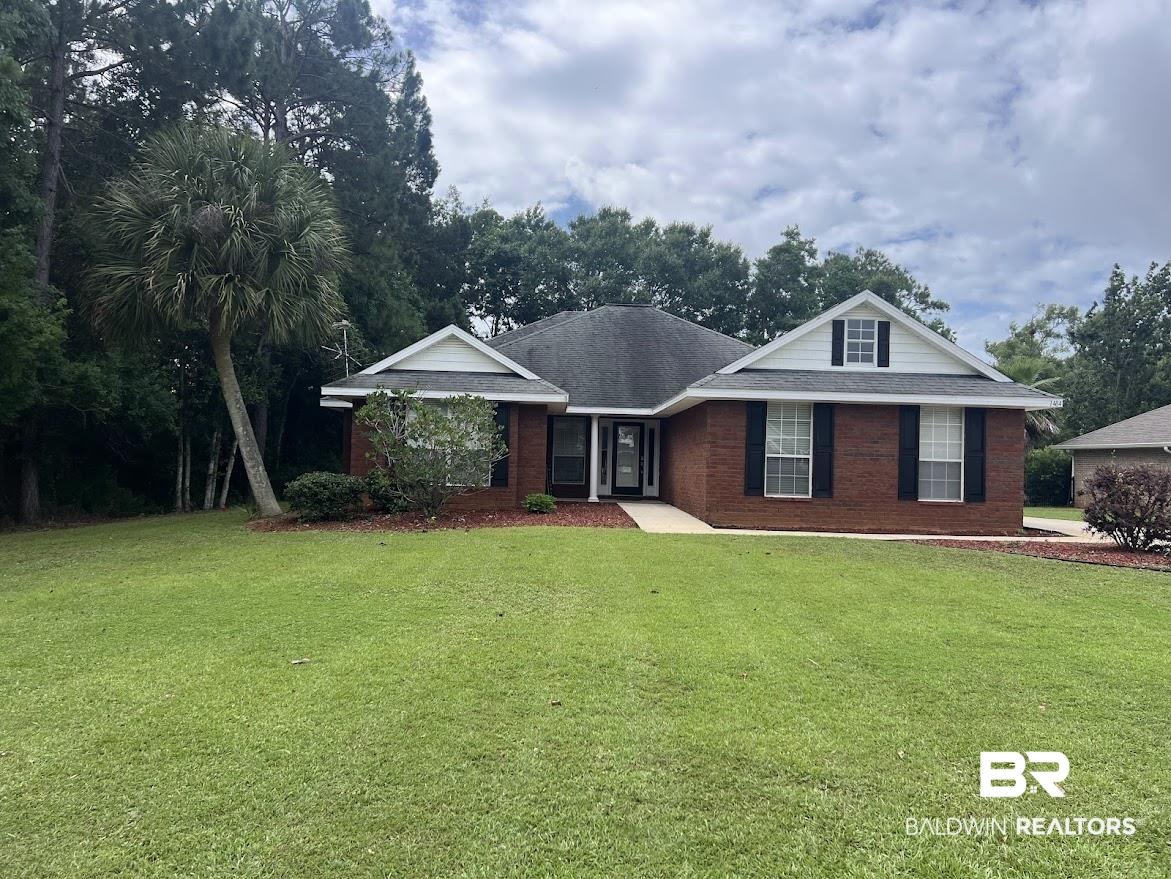 Image 2: Brick facade residence with a prominent front dormer, black window shutters, a covered entry, and an expansive lawn