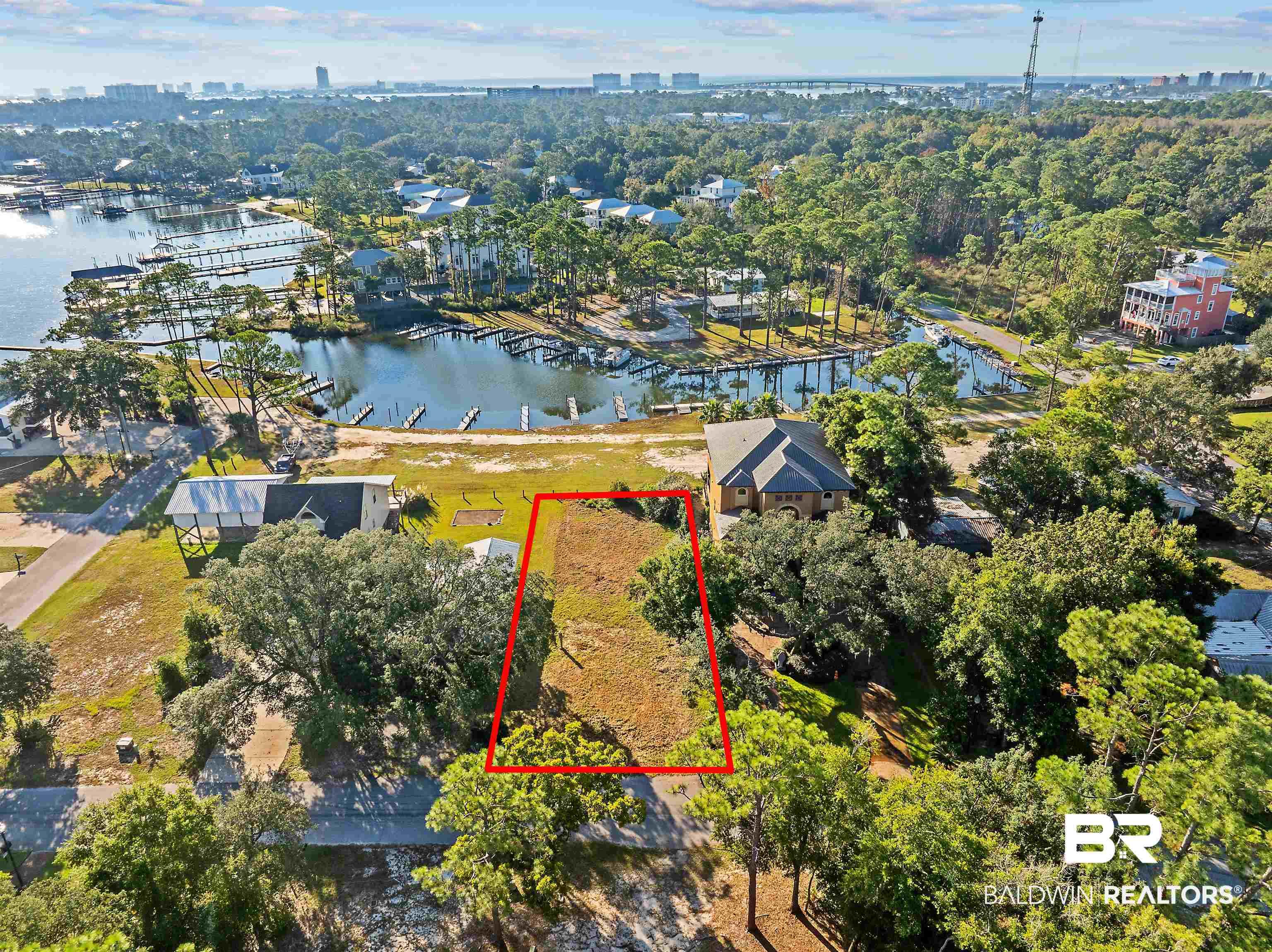 Image 3: Aerial view of property and surrounding area with property boundaries highlighted and a large body of water