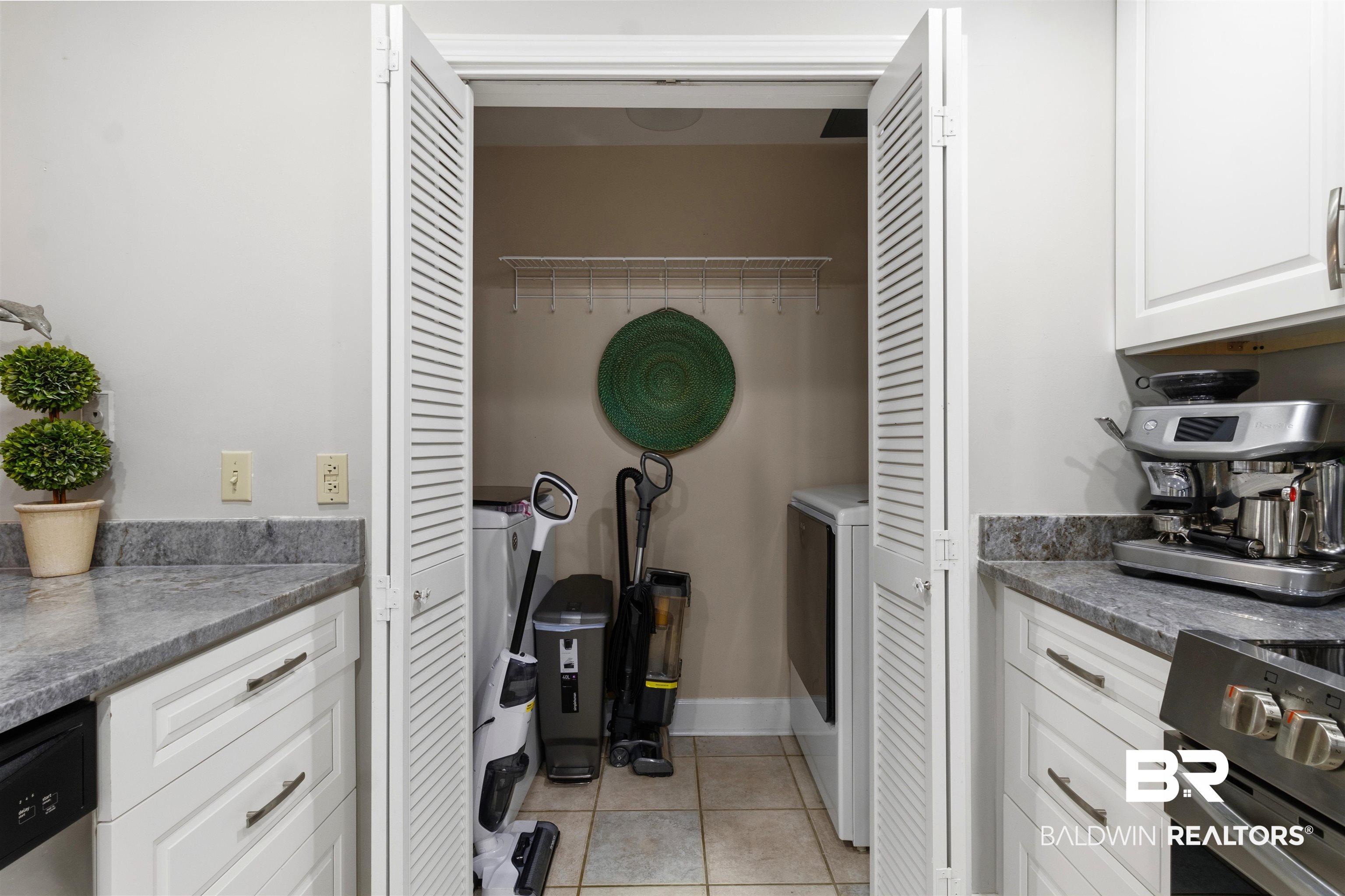 Image 4: Integrated laundry closet with louvered bi-fold doors, tiled flooring, and a wire shelf