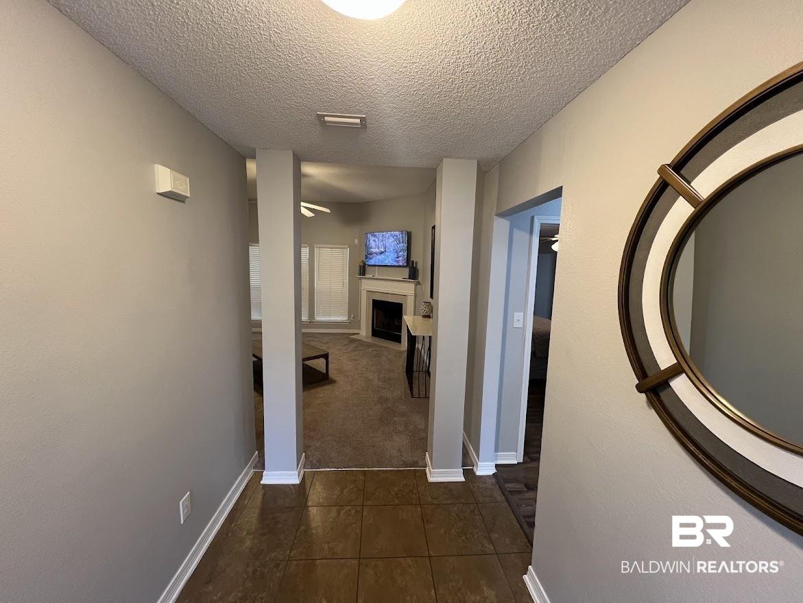 Image 4: Tiled entry hall with light grey walls and white baseboards