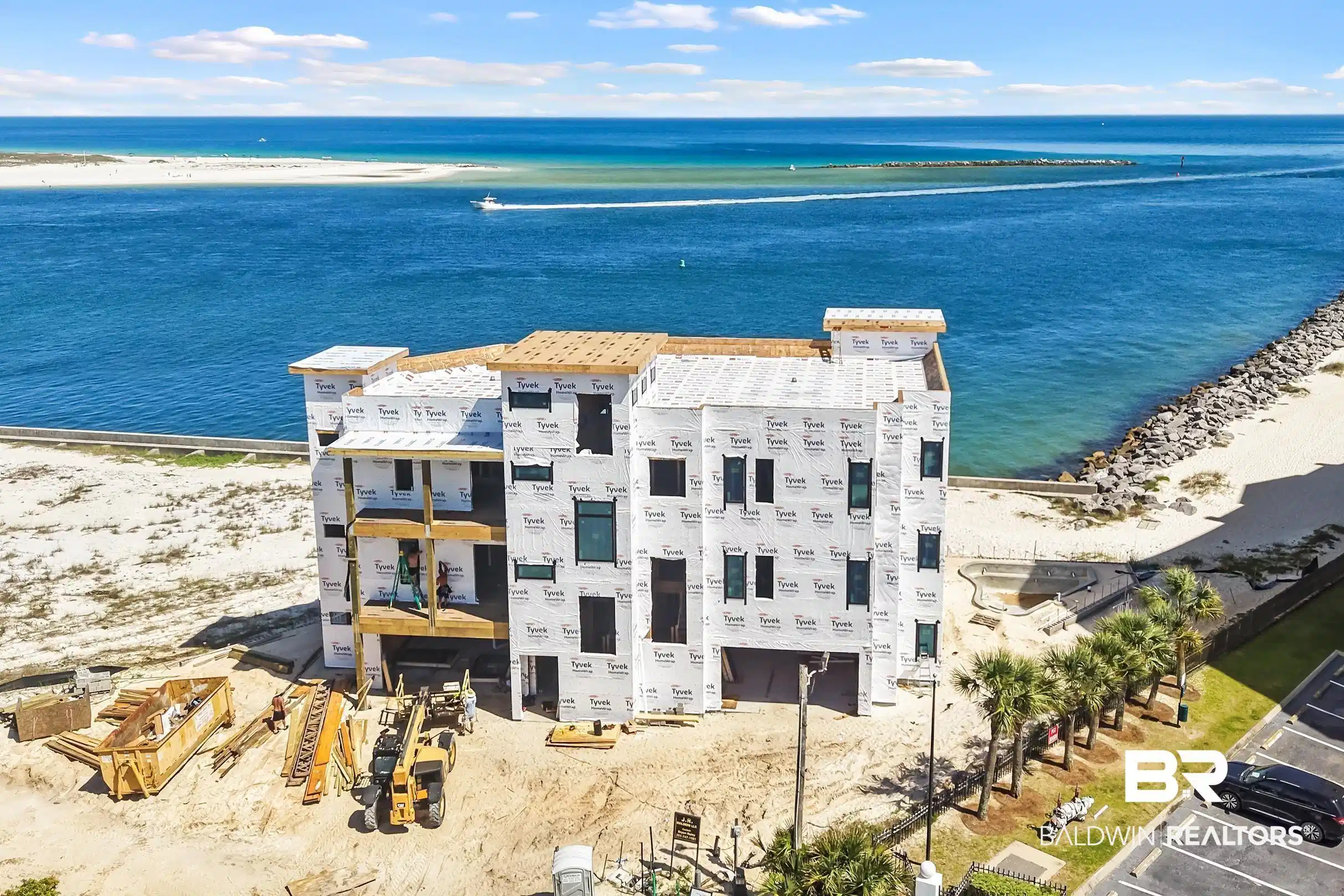 Image 1: Waterfront multi-story structure under construction featuring multiple balconies, direct beach access, and an adjacent parking area featuring 2 luxury condos