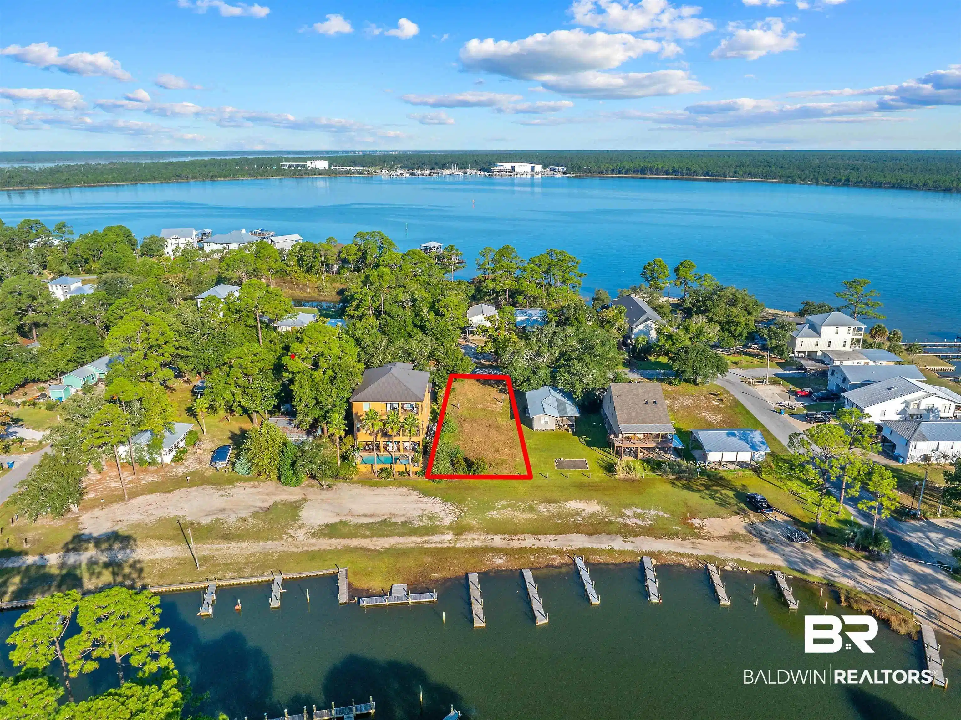 Image 1: Aerial view of residential area with a large body of water and property boundaries highlighted