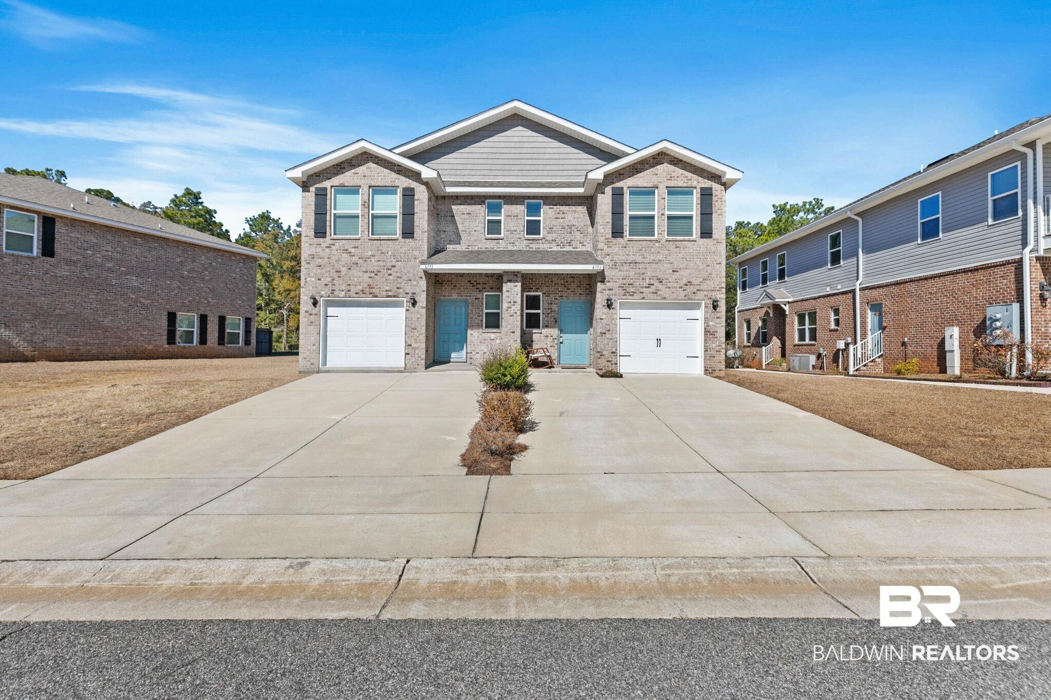 Image 1: View of front of home featuring a garage, brick siding, and concrete driveway