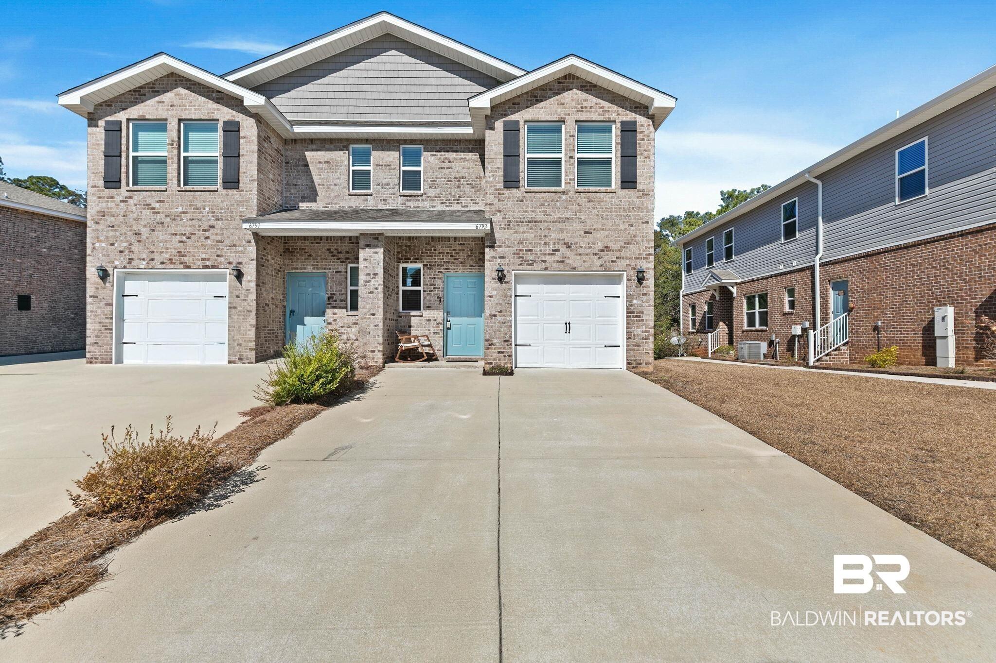 Image 2: View of front facade featuring an attached garage, brick siding, concrete driveway, and a porch