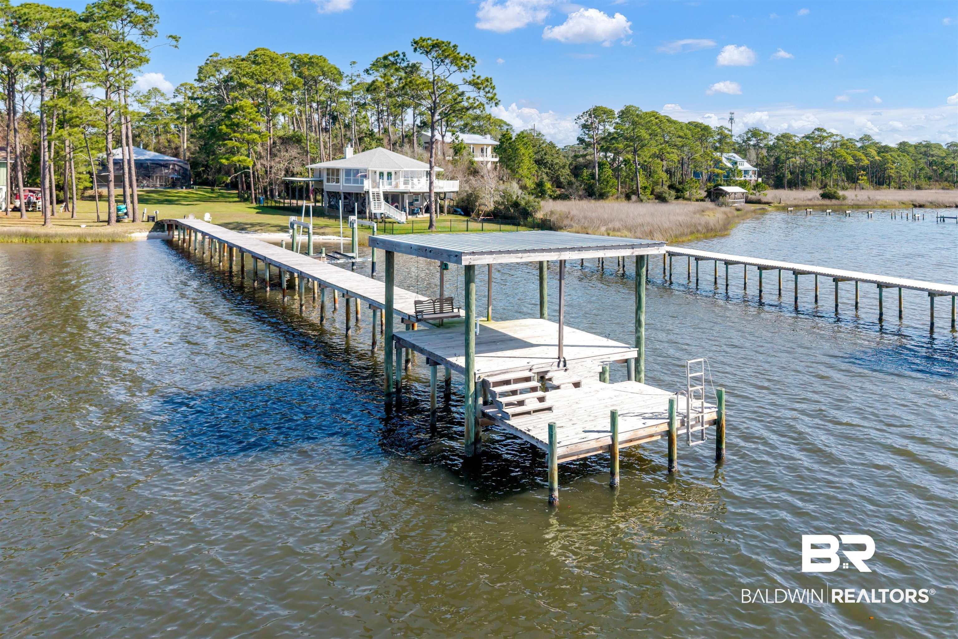Image 4: Dock featuring a water view and view of scattered trees