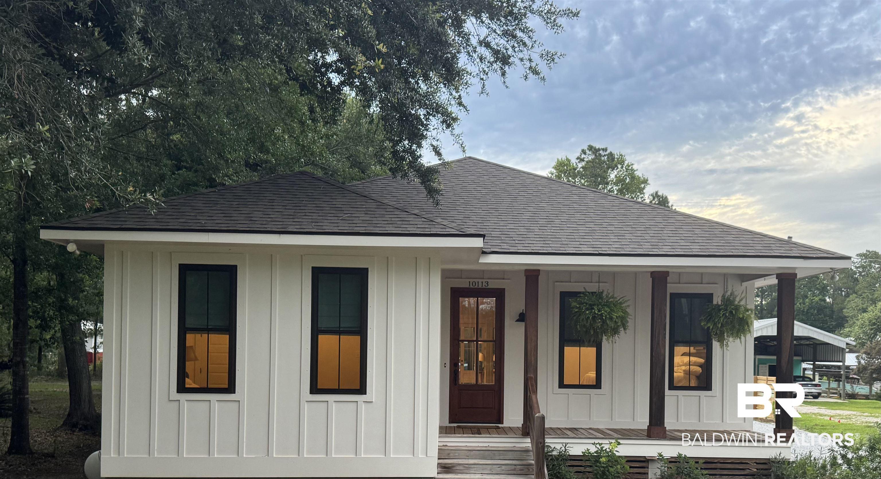 Image 1: White board and batten exterior with a dark shingle roof