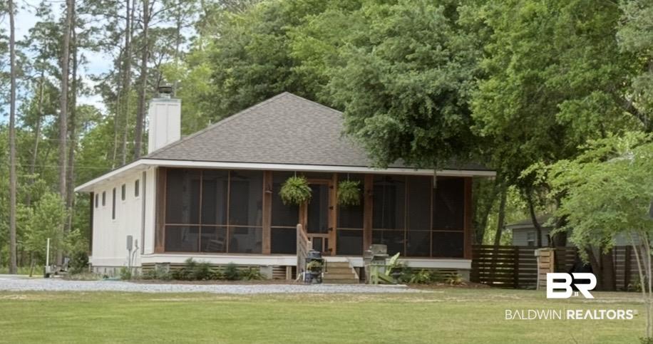 Image 2: White siding residence featuring a screened-in front porch with wooden support beams and a shingle roof