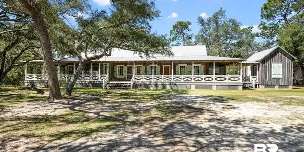 Image 3: View of front of home featuring metal roof, covered porch, and board and batten siding