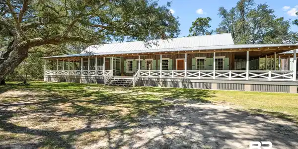 Image 4: Farmhouse inspired home featuring an exterior structure, metal roof, and an outbuilding