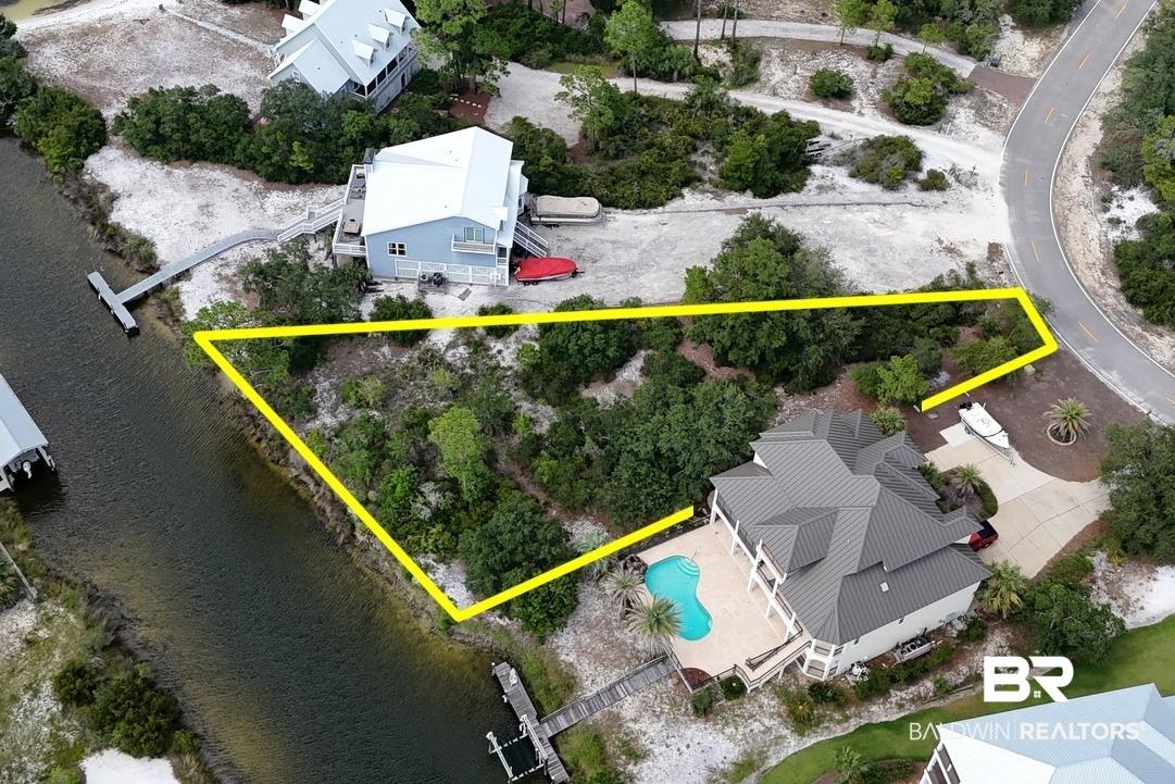 Image 1: Aerial view of property and surrounding area with property boundaries highlighted and a nearby body of water