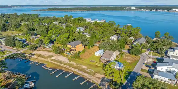 Image 4: Aerial overview of property's location featuring a large body of water and nearby suburban area