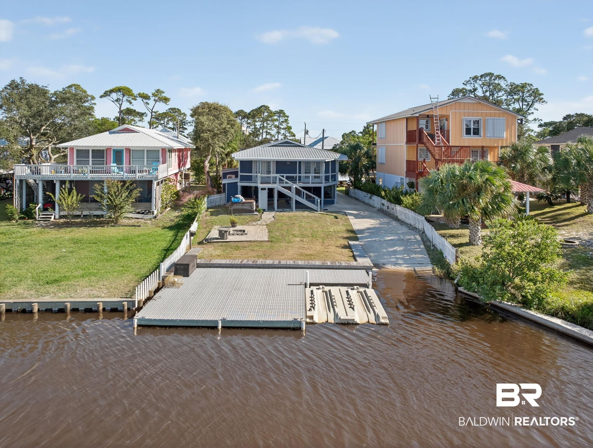 Image 2: Dock with a water view, a lawn, and a boat ramp