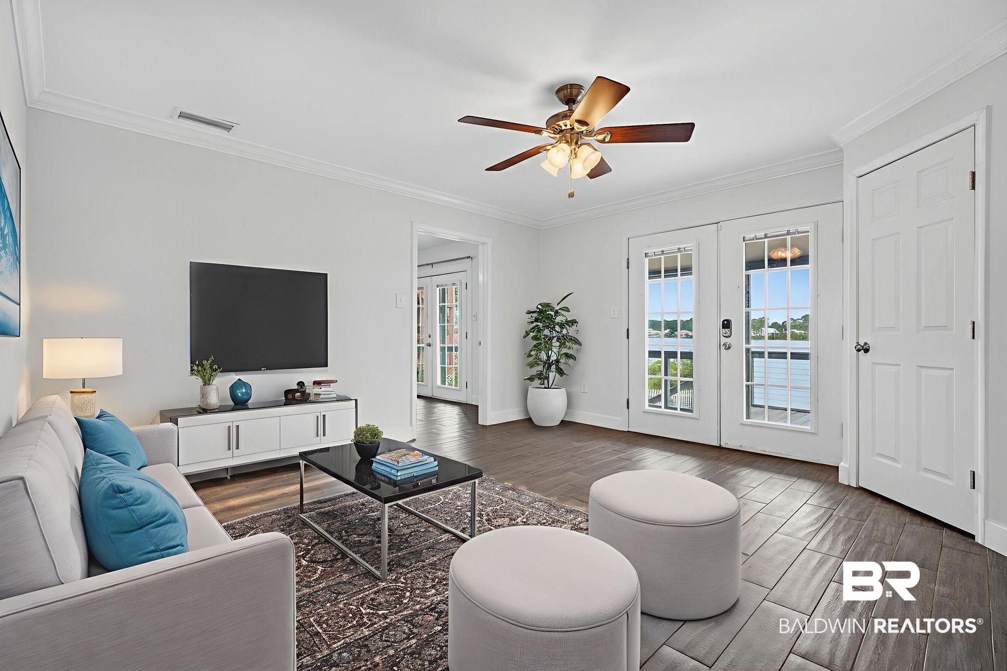Image 4: Living area featuring french doors, dark wood-type flooring, ornamental molding, and ceiling fan