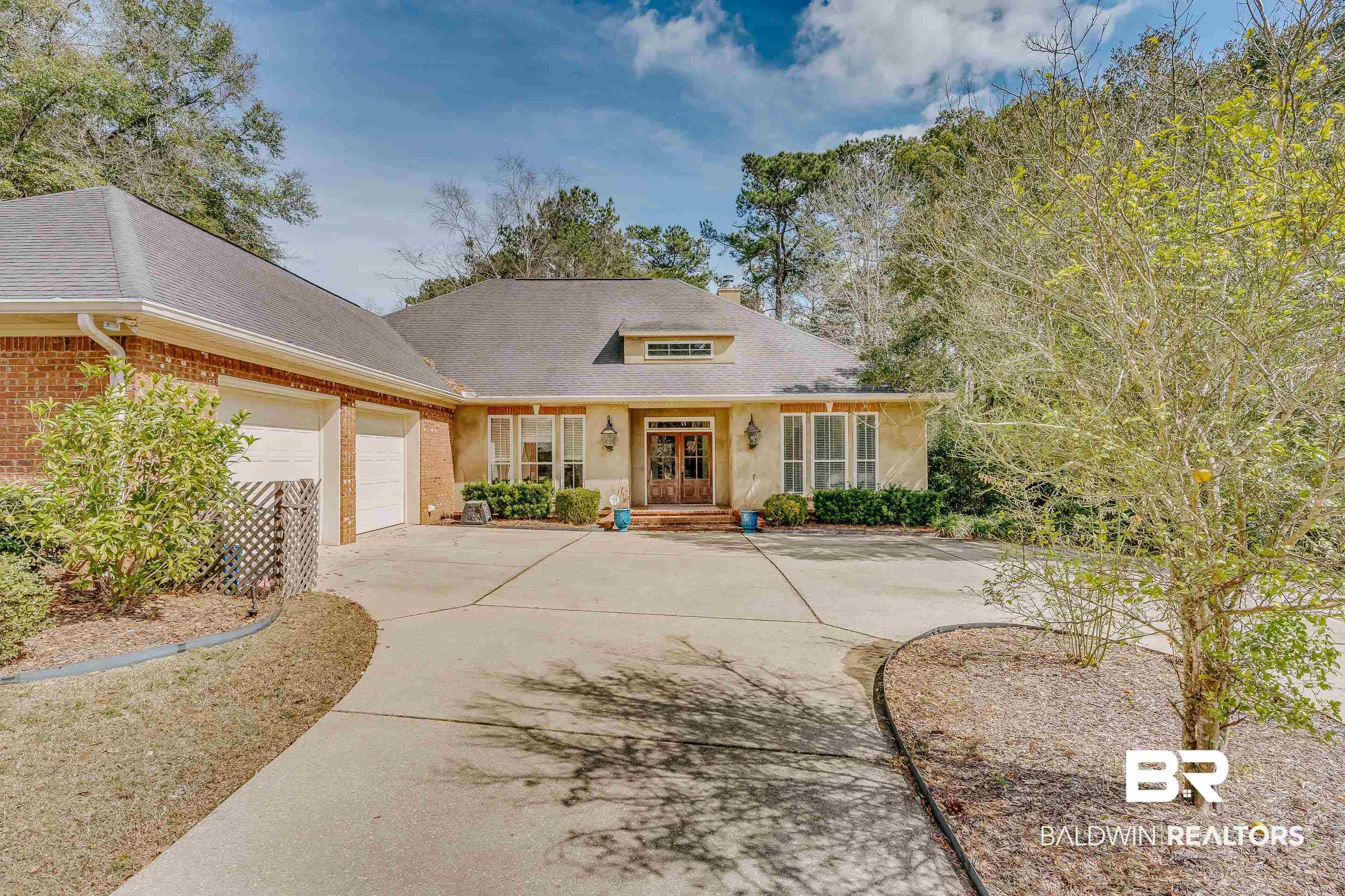 Image 1: View of front of home featuring a shingled roof, driveway, a garage, and brick siding