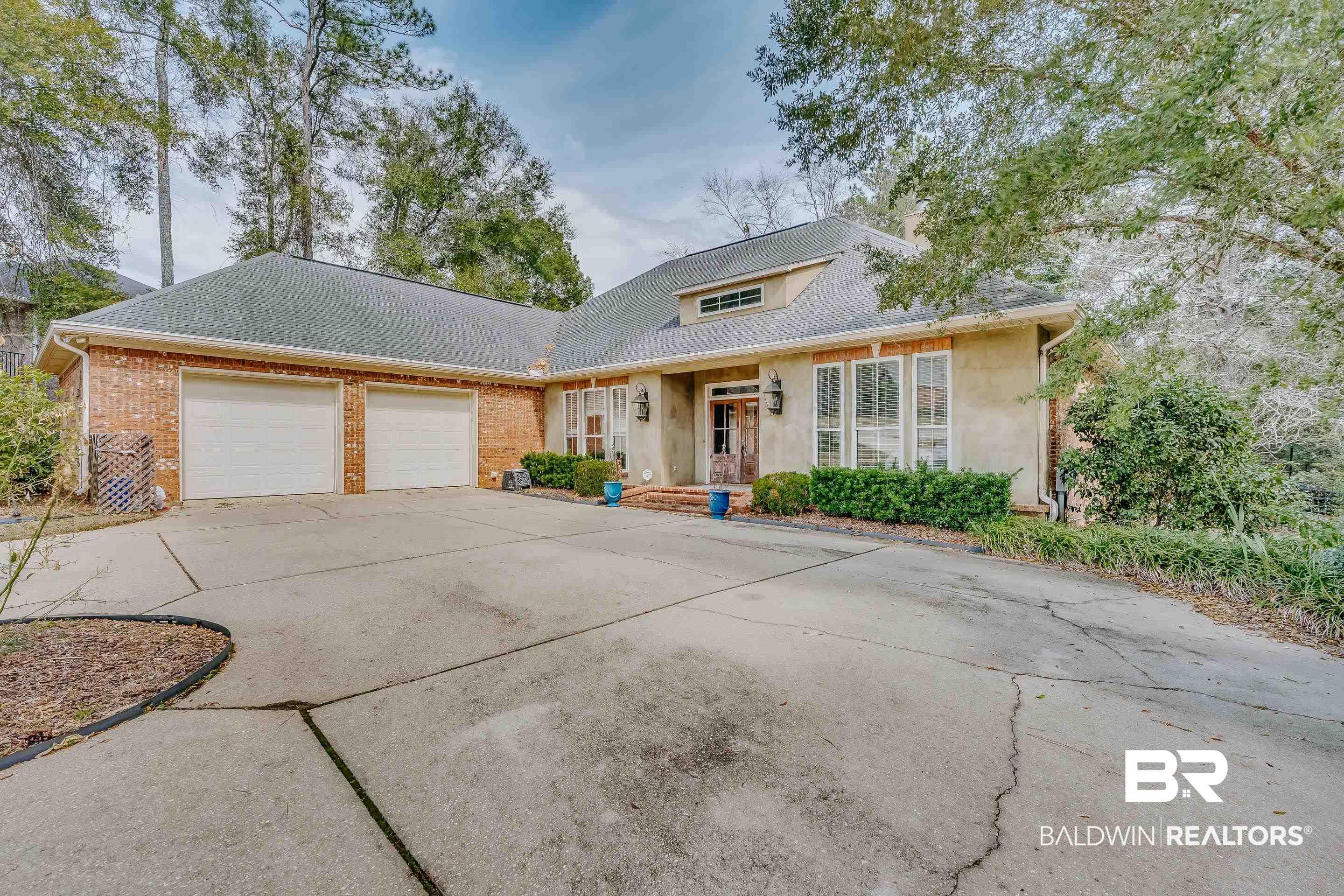 Image 2: View of front of home featuring driveway, a garage, brick siding, and roof with shingles