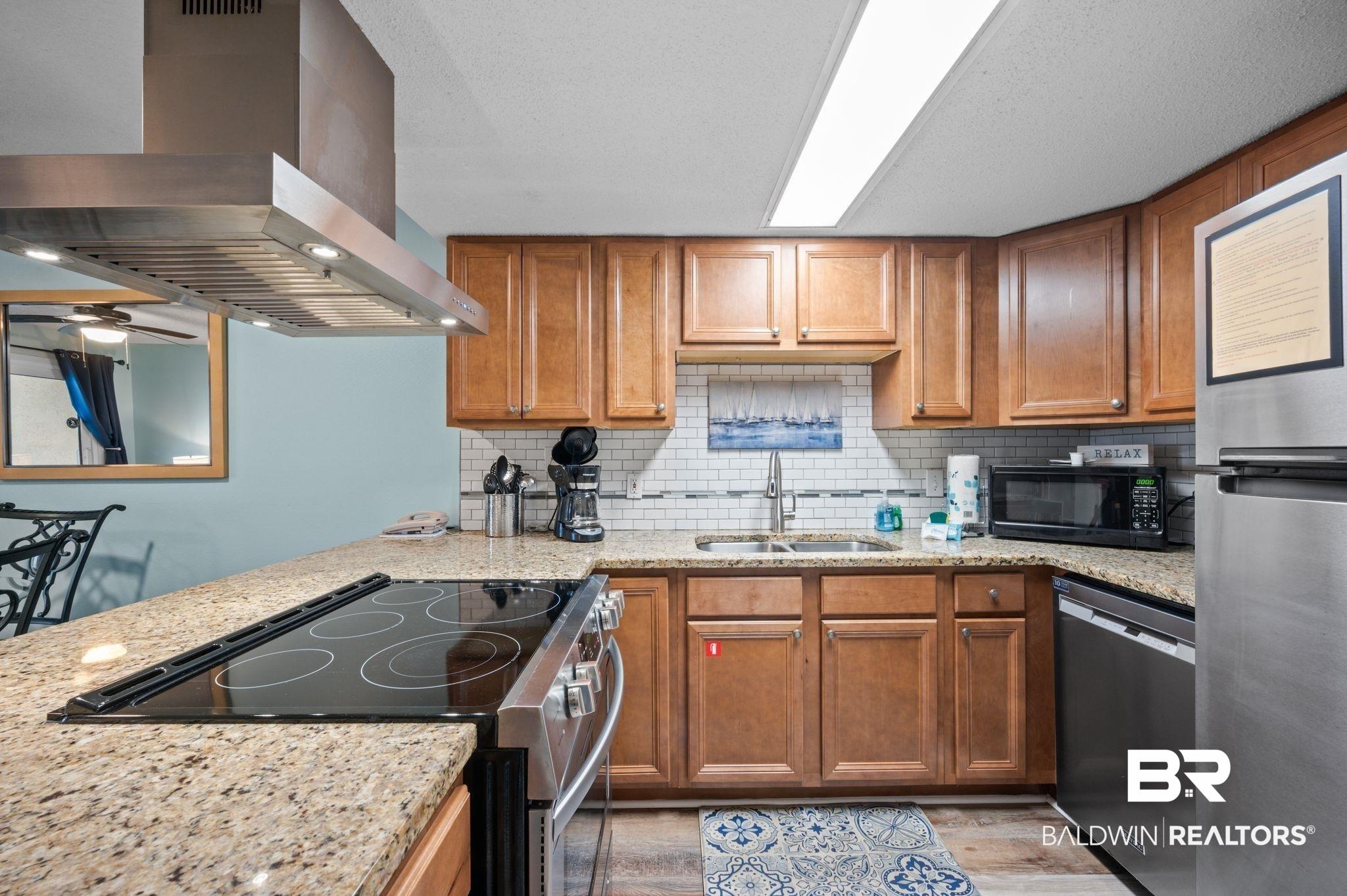 Image 3: Kitchen featuring a sink, black microwave, range hood, electric stove, and stainless steel dishwasher