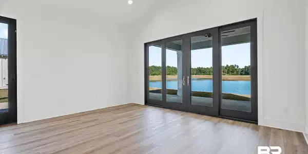 Image 2: Spare room featuring light wood-style flooring, high vaulted ceiling, a ceiling fan, recessed lighting, and a water view