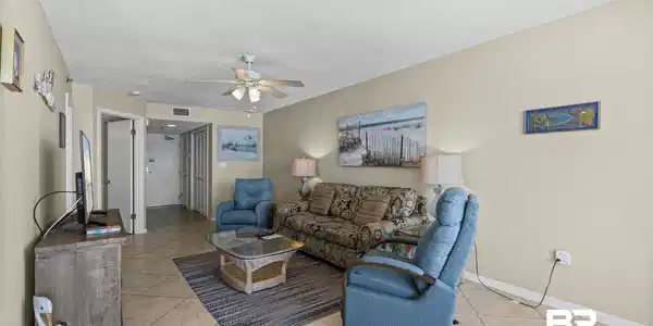 Image 4: Living area featuring neutral wall tones, tile flooring, and a ceiling fan with integrated lighting