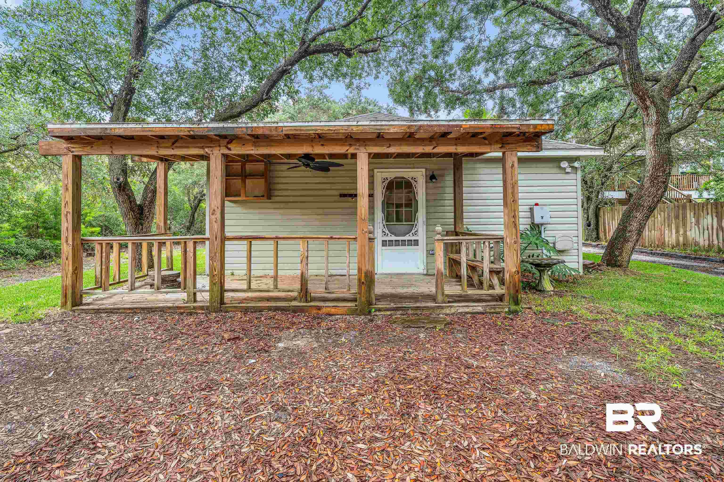 Image 3: Covered porch with wood frame and railing, featuring a ceiling fan and integrated storage