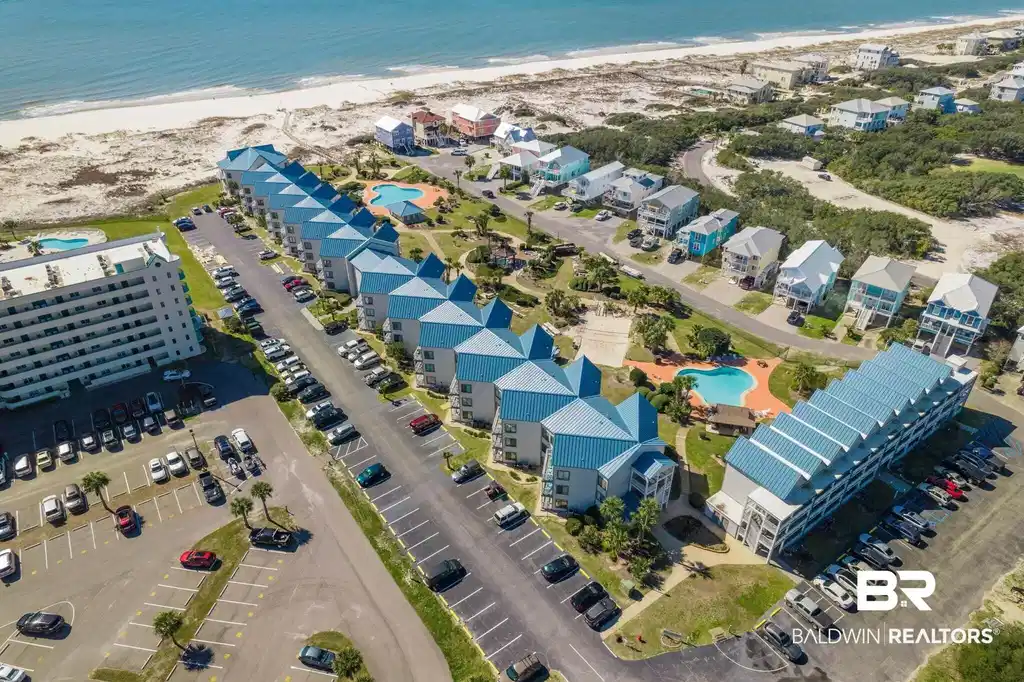 Image 1: Bird's eye view of expansive beach and a pool area