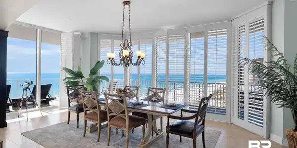 Image 3: Dining area with floor to ceiling windows, a water view, and a chandelier