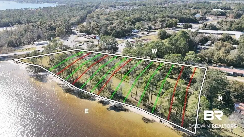 Image 1: Aerial view of property and surrounding area featuring a nearby body of water and property parcel outlined