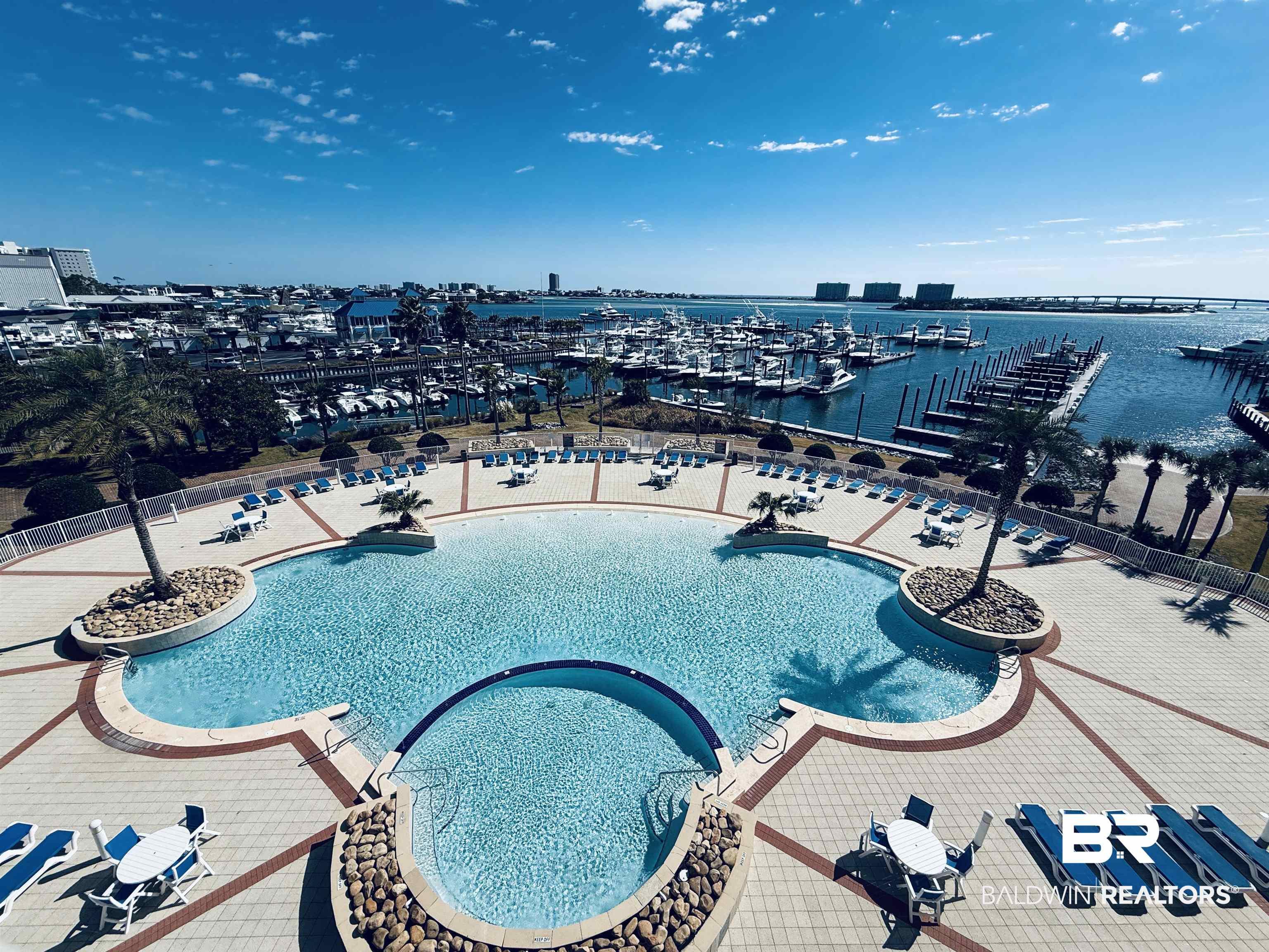 Image 2: Community pool with a water view and view of marina