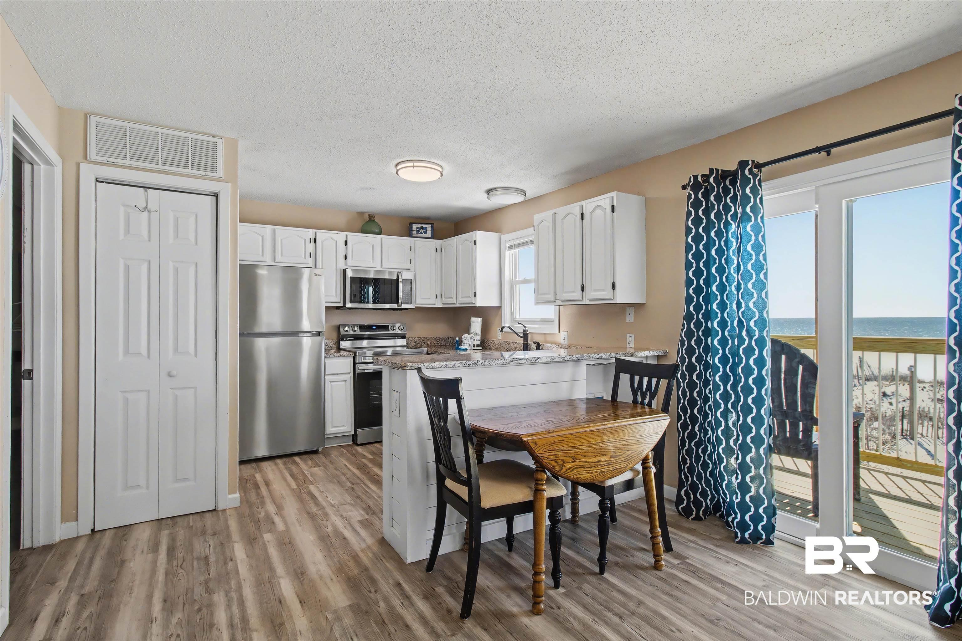 Image 2: Dining space featuring light wood finished floors and a textured ceiling