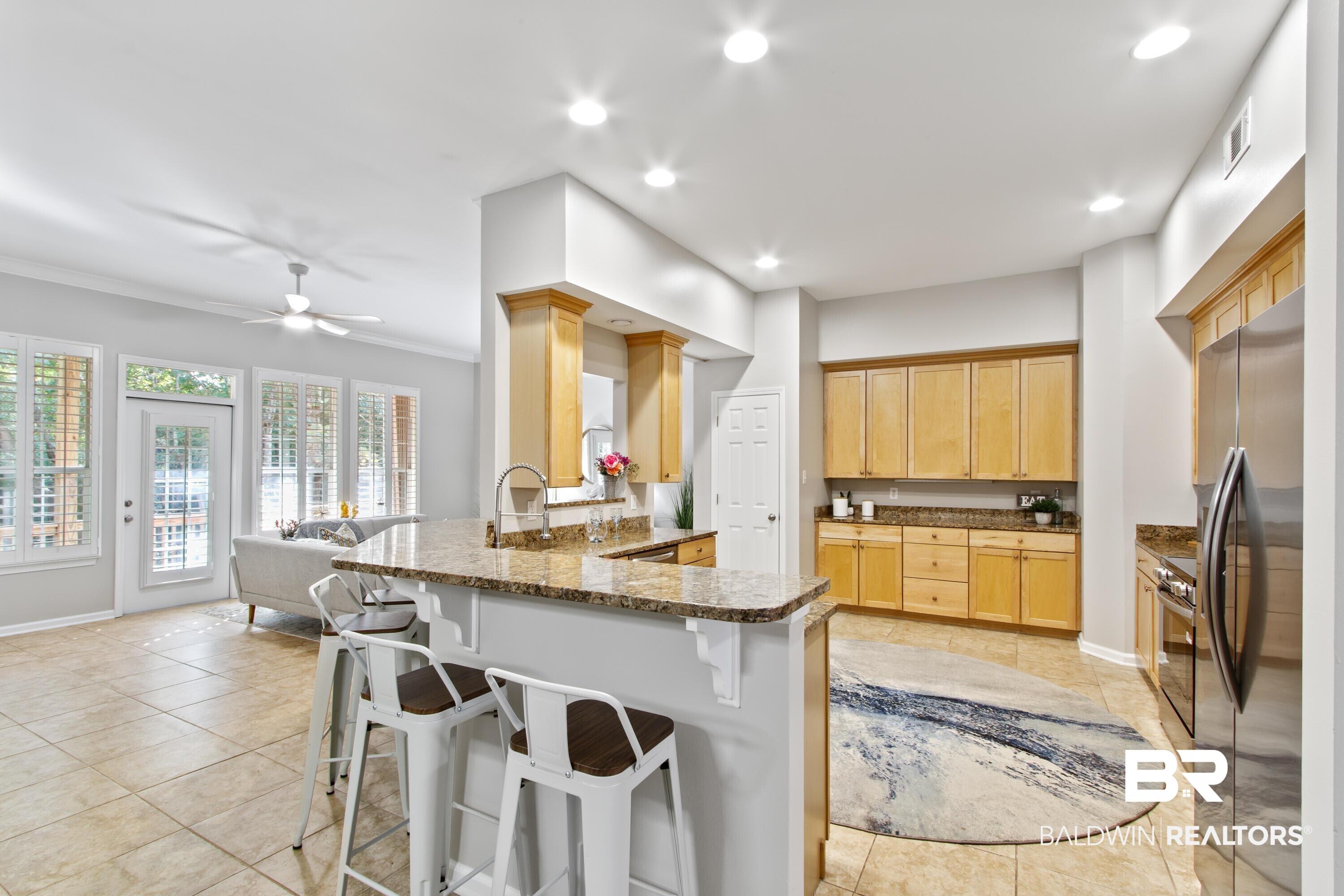 Image 2: Kitchen with a peninsula, a breakfast bar area, appliances with stainless steel finishes, open floor plan, and recessed lighting