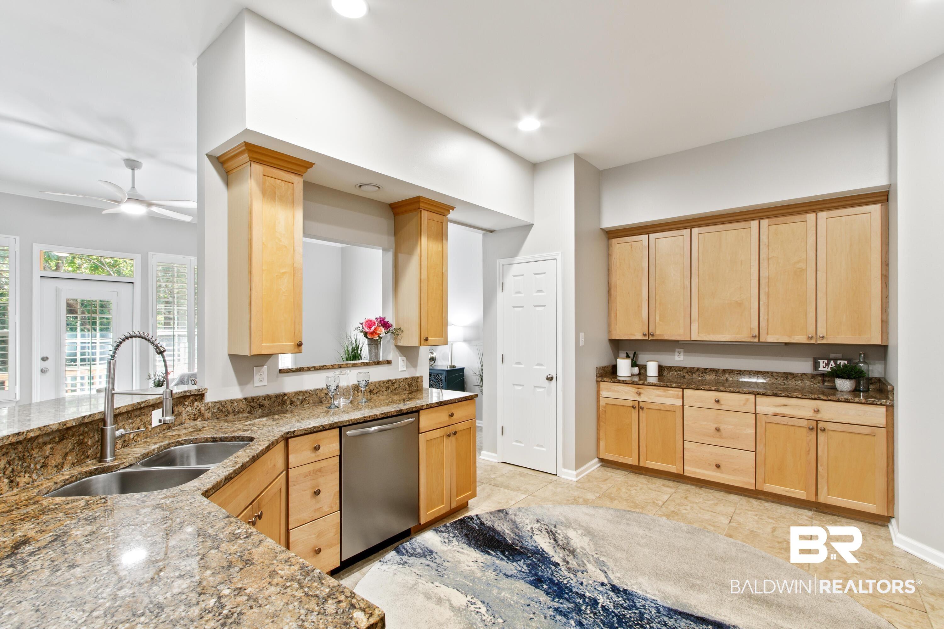 Image 3: Kitchen with light brown cabinetry, dark stone counters, dishwasher, ceiling fan, and recessed lighting