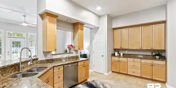 Image 3: Kitchen with light brown cabinetry, dark stone counters, dishwasher, ceiling fan, and recessed lighting