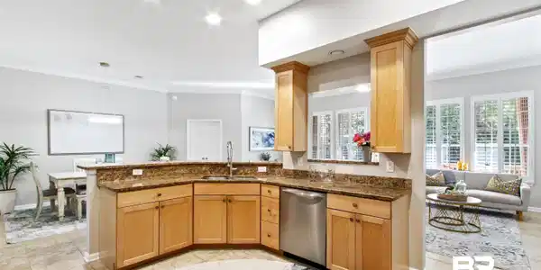 Image 4: Kitchen with crown molding, dark stone countertops, decorative light fixtures, light tile patterned flooring, and stainless steel dishwasher