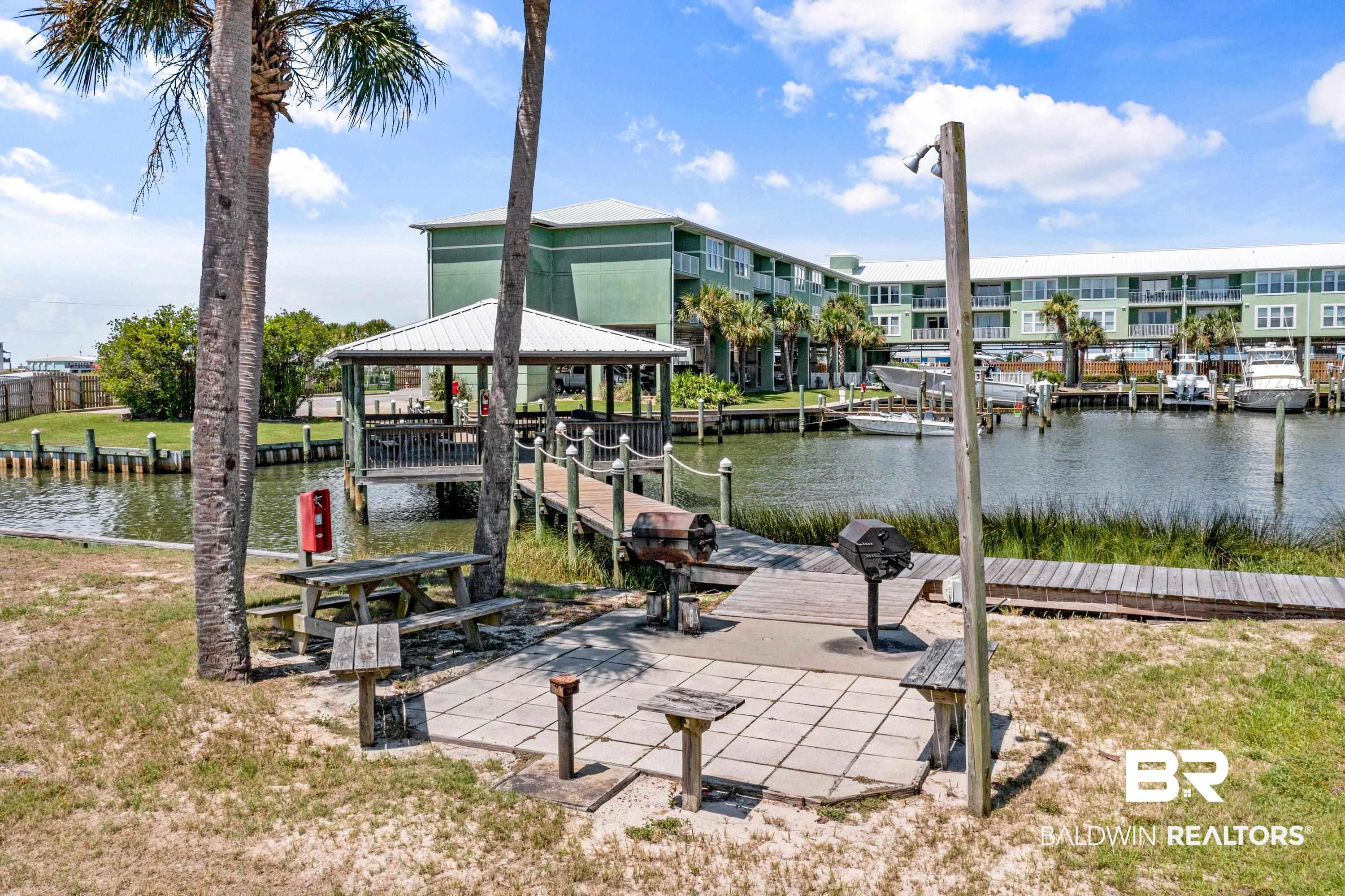 Image 4: Dock featuring a water view and a yard