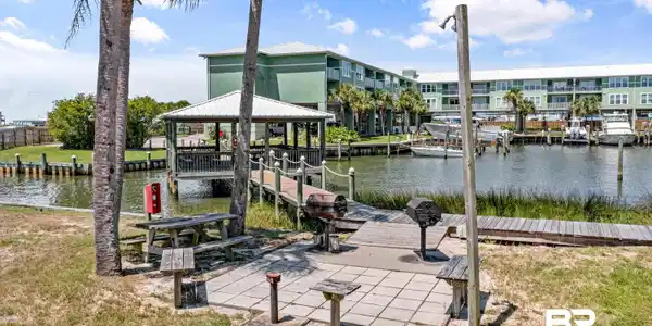 Image 4: Dock featuring a water view and a yard