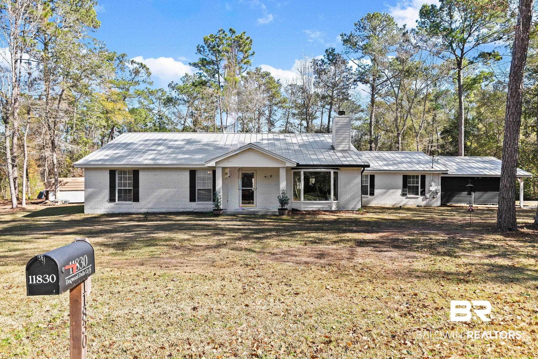 Image 1: Ranch-style house featuring brick siding, a front yard, a chimney, a porch, and a metal roof